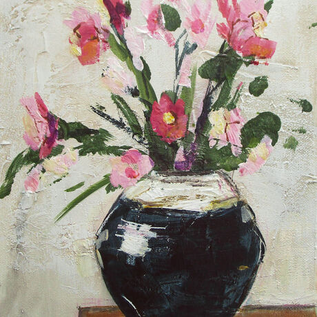 pink and red flowers in a shiny, blue, ceramic vase against a wall of textured white plaster