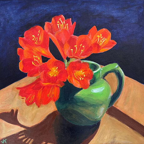 Orange clivia in a mid green Art Deco milk jug on a deep blue background.