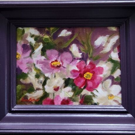 Spontaneous detail of colourful Ranunculi flowers in a matching plum-coloured frame