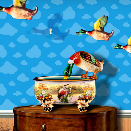 A flying porcelain duck leaves the wall to drink from a table vase