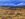 An abandoned house in the middle of a barren outback landscape.