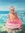 Child standing in the ocean in a pink doughnut