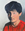 A bi-racial boy (Asian and White) with an unkempt mop top haircut and bright red shirt wears a calm expression infant of a modulated grey background. 