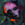 A disfigured pink face with neon orange splice, green background, heavy texture, magenta spray paint splattered and dripping near right ear of face, spliced abstract shapes in background, dark green hues in background, high contrast, canvas has been repeatedly pierced through, mirror has been fixed to the back of canvas so the viewer can see themselves in painting