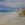 The moment of change. A seascape with a changing sky with rain on the horizon, the air is charged with exhilarating energy. The entry is a row of sand dunes on the right with the turquoise sea on the left. 