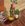 A stool, a stack of books, pot plants in a living room
As the afternoon light filters in 