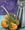 three Mandarines and leaves resting on a table. the mandarines are reflected on a kitchen oil can 