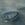 Small boat drifting on the sea with misty headlands in the background.