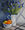 Blue irises in an enamel dairy jug with a bowl of citrus fruit