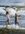 A young boy and girl run in opposite directions arms out flung as they face a wild breaking wave. The ocean is a churning mass of water and the last light of the day paints the children gold.