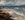 Stormy seas crashing onto the beach, foreground rocks