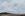 Mountains country with flat pasture in foreground and a storm over the background mountains