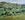 A road leading into a valley with grazing cows in the foreground.