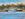 View across the water to a  boat moored at a jetty in front of some fishing huts