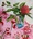 A turquoise glass vase holds a single waratah on top of Australian motif pink tablecloth