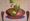 Lettuce and tomato falling into a wooden bowl on a retro patterned background 