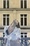 A woman with her head tipped up in front of a Parisian balcony 