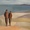 Two people walking together on the beach