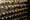 An image of a wine cellar with a close up of the bottles in shades of brown and black