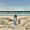 Woman and child walking through dunes to beach