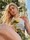 A portrait of a woman sitting in the sun picking sunflowers