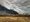 Golden fields of mown crops with a dramatic stormy sky.