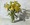 Yellow lilies flowers in a glass jar on a table lit by the sun.

