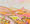 An imaginary landscape with a variety of hills, mountains and fields with different trees lining fields under a soft pink sky - everything is kept in pink and yellow tones. 