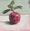 an original painting of a red apple with leaves attached, painted in acrylics on board, ready to hang with chord fastened to the back.