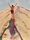 artwork featuring a man climbing towards the top of an enormous sand dune
