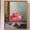 A pink velour round chair on a silver base with a side table and lamp. Plain wall behind with part of  a timber sliding door on the left behind the table. 