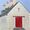 A vineyard cellar in France with a big red cellar door, chimneys and slate roof.