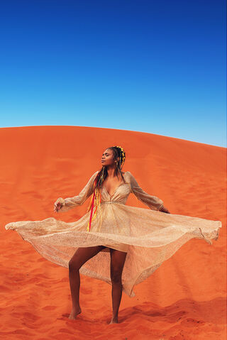 Photograph of beautiful Aboriginal model dancing in the red dirt of Uluru