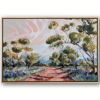 Spring grasses edge a red dirt track that weaves through mallee trees. A pink and blue sky have white whispering clouds. 