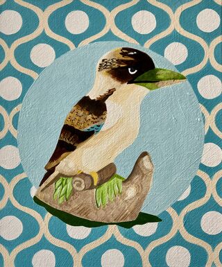 A kookaburra figurine set on a blue beige and white patterned background 