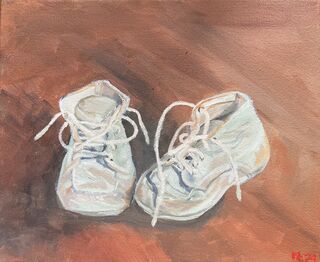 A pair of vintage childrens boots sitting on a timber floor