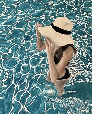 An image of a girl standing waist deep in beautiful aqua water in a floppy sun hat