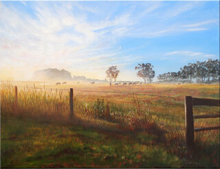 The misty golden glow of sunrise throws long shadows and stripes of light across a rural scene, with cows grazing in the distance.  In the foreground, dewdrops sparkle in the grass and along the wire fence.