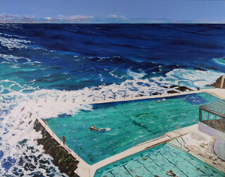 under a lovely light blue, pink and white morning sky, with the deep dark blue ocean in the far distance, rocky coastline and the two ocean pools known as Icebergs at Bondi Beach with some big waves smashing into the outer pool edge and parts of the iconic building of Surf Life Saving Australia.