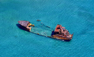 The images in my ‘Rust Coast’ series were taken on a short section of coastline east of Honiara in the Solomon Islands. Ships and vehicles that reach the end of their usefulness are dumped along the shoreline.  In the 12 years that I have been visiting this location I have recorded the changing seascape as rusting hulks are stripped, some metal salvaged and then left to rust away, and new wrecks added. Local people with limited resources eke a living in their shadows. The compositions change but the elements of rusting waste and poverty have remained the same. 