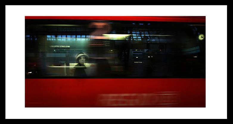 Window reflection in moving red train.