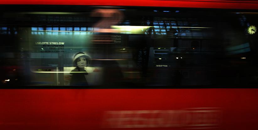 Window reflection in moving red train.