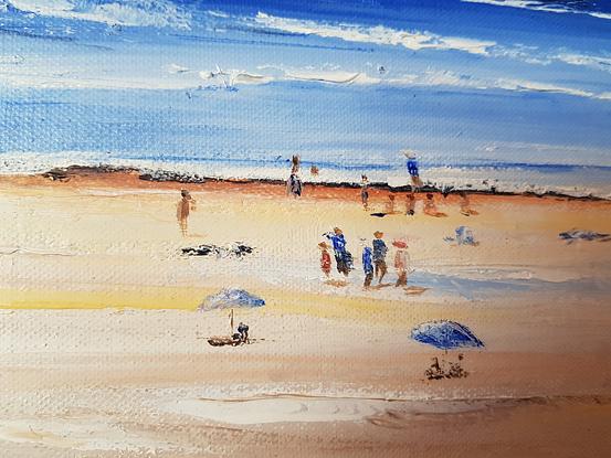 Long and wide beach. People walking on the sand. People sitting under umbrellas. Others sitting on the sand. Greenery and wild flowers on the foreground. Hills in the horizon. 