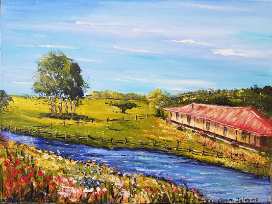 Red roof country house near a river. Some trees in the background. Colourful wildflowers in the foreground. 