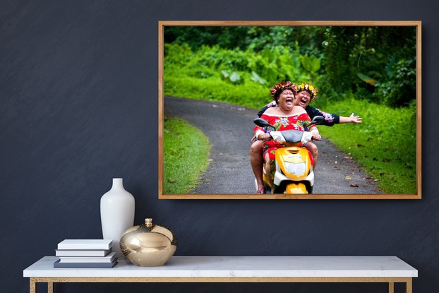 Two happy women ride a motorbike in the Cook Islands