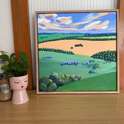 Trees in green and orange fields under colourful cloudy sky