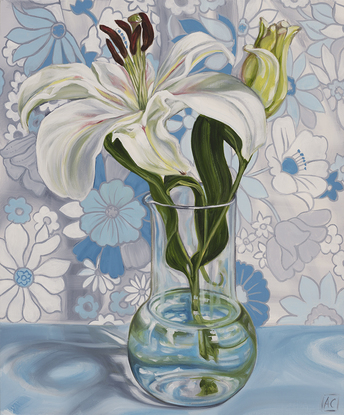 White lilly in glass vase against a 70's daisy fabric