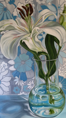 White lilly in glass vase against a 70's daisy fabric