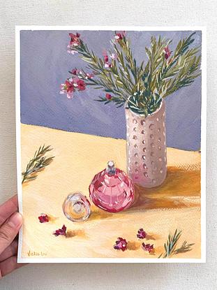 Little flowers in vase with pink perfume bottle