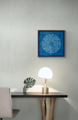 a square image, of a blue biomorphic pattern based on a plaster carving from the Attarine Madrasa in Fez. Inside the square, is a circular emblem that is filled with arabesque pattern detail. it is framed inside a natural wood float-frame